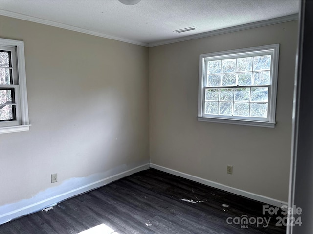 unfurnished room with dark hardwood / wood-style flooring, a textured ceiling, and ornamental molding