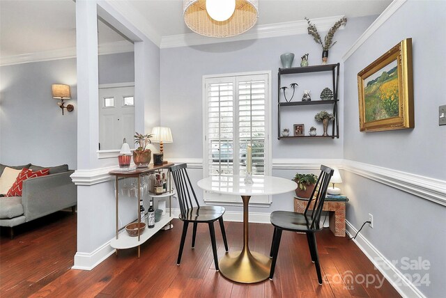 dining room with dark hardwood / wood-style flooring and crown molding