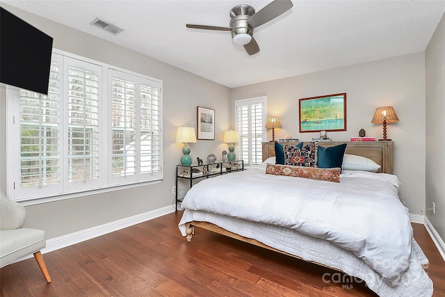 bedroom with multiple windows, ceiling fan, hardwood / wood-style floors, and a textured ceiling