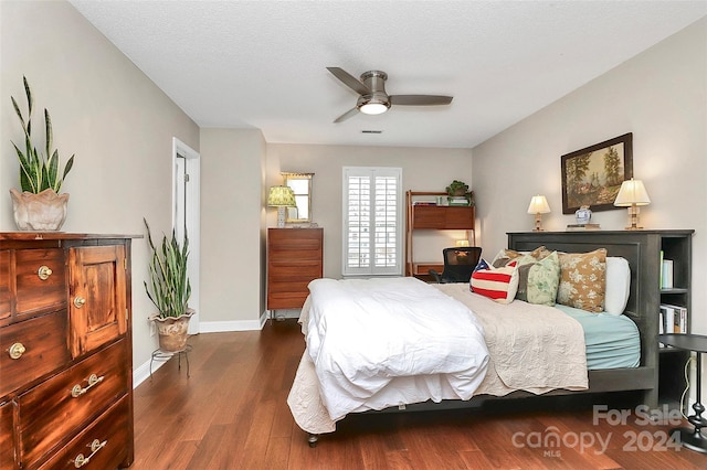 bedroom featuring a textured ceiling, ceiling fan, and dark wood-type flooring