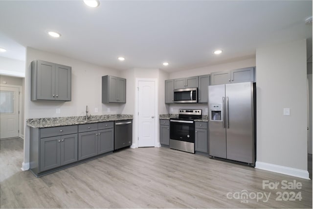 kitchen featuring gray cabinetry, sink, stainless steel appliances, and light hardwood / wood-style flooring