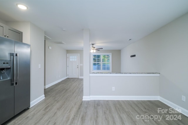 kitchen with light stone countertops, stainless steel fridge, light hardwood / wood-style floors, and ceiling fan