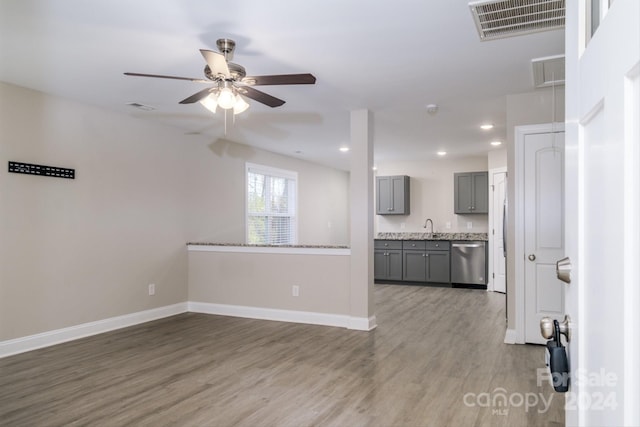 unfurnished living room with hardwood / wood-style flooring, ceiling fan, and sink