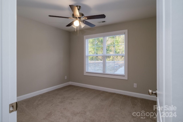 empty room featuring ceiling fan and light carpet