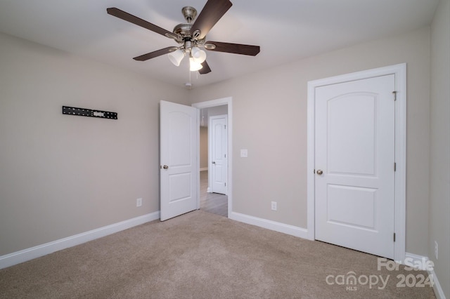 unfurnished bedroom with ceiling fan and light colored carpet