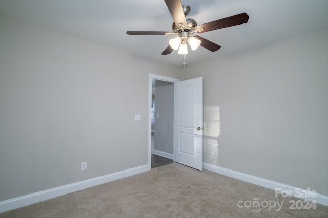 carpeted spare room with ceiling fan