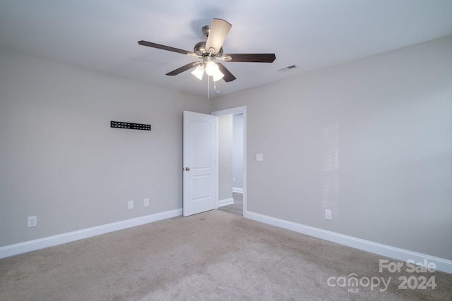 carpeted spare room with ceiling fan