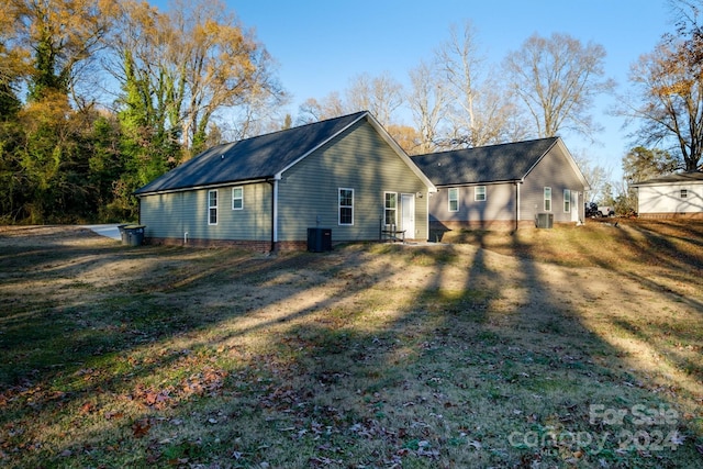 back of house featuring a lawn and central AC