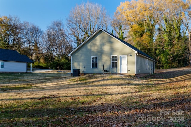 back of house with a lawn and central AC