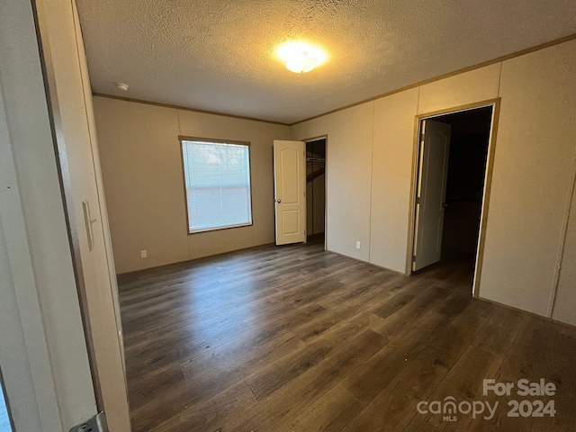 unfurnished bedroom with a textured ceiling and dark hardwood / wood-style floors