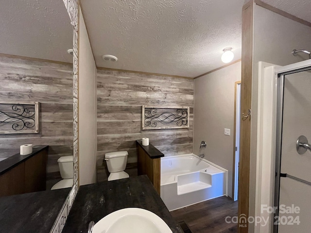 full bathroom featuring a textured ceiling, separate shower and tub, hardwood / wood-style floors, toilet, and wood walls