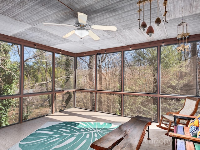 unfurnished sunroom with ceiling fan