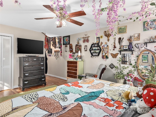 bedroom with baseboards, wood finished floors, and a ceiling fan