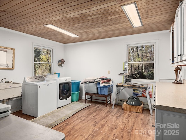 laundry area featuring wood ceiling, ornamental molding, washing machine and dryer, and light wood-style floors