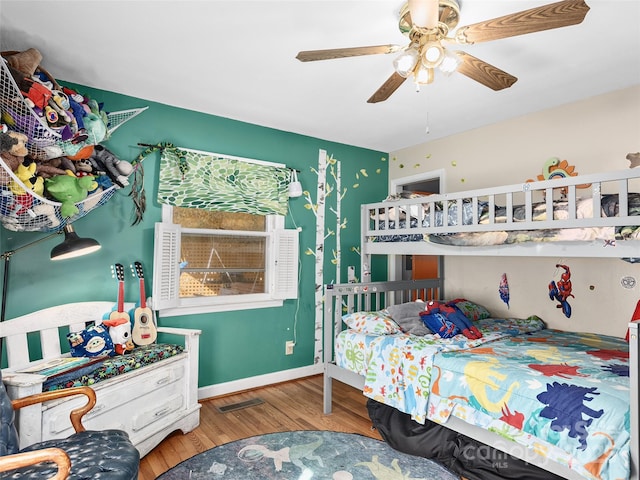 bedroom with visible vents, baseboards, ceiling fan, and wood finished floors