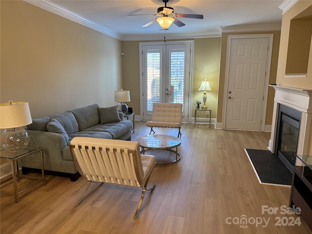 living room with crown molding, french doors, ceiling fan, and light wood-type flooring