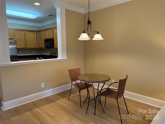 dining area featuring an inviting chandelier, light hardwood / wood-style flooring, and ornamental molding