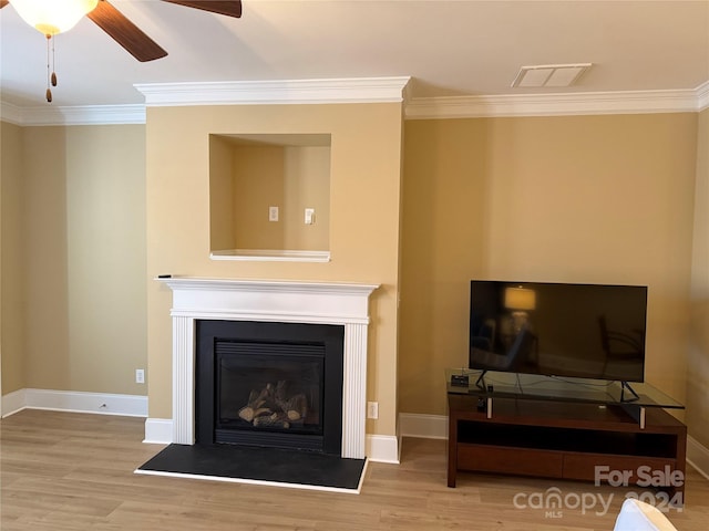 living room featuring ceiling fan, light wood-type flooring, and crown molding