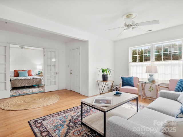 living room featuring hardwood / wood-style floors and ceiling fan