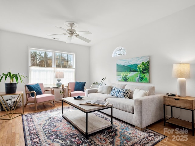 living room featuring a healthy amount of sunlight, wood-type flooring, and ceiling fan