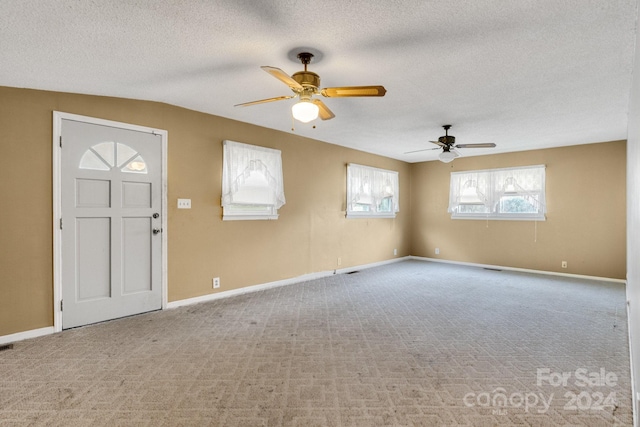 carpeted foyer entrance with ceiling fan, lofted ceiling, and a textured ceiling