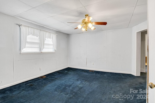 unfurnished room with dark carpet and ceiling fan