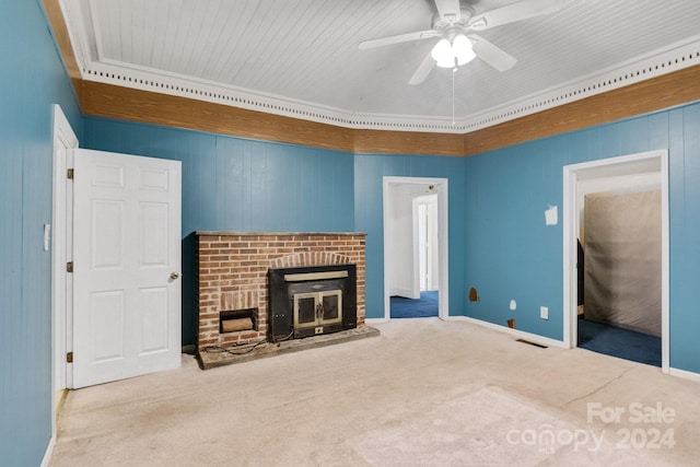 unfurnished living room with ceiling fan, wood walls, carpet floors, and ornamental molding