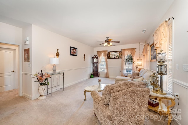 living room with ceiling fan, plenty of natural light, and light carpet