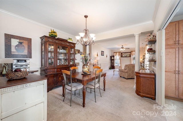 carpeted dining room with ceiling fan with notable chandelier, decorative columns, and crown molding