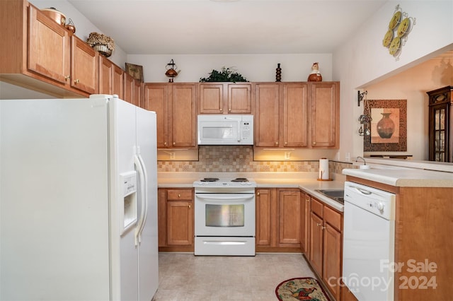 kitchen with decorative backsplash, white appliances, and kitchen peninsula