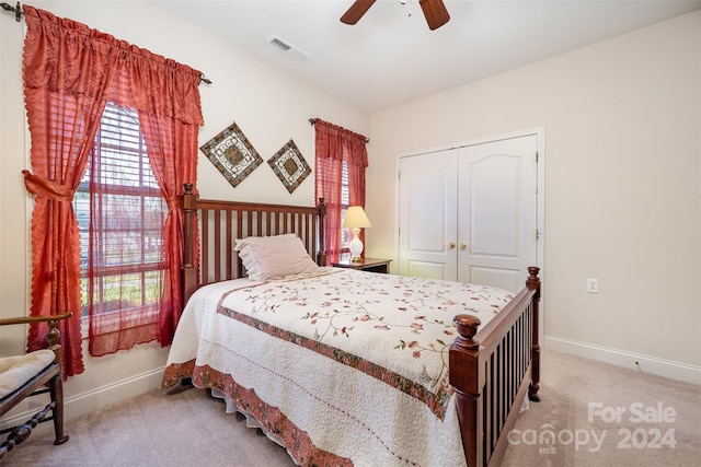 bedroom featuring ceiling fan, light colored carpet, and a closet