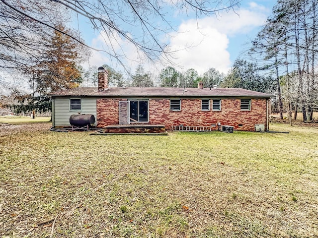 rear view of property with cooling unit and a lawn