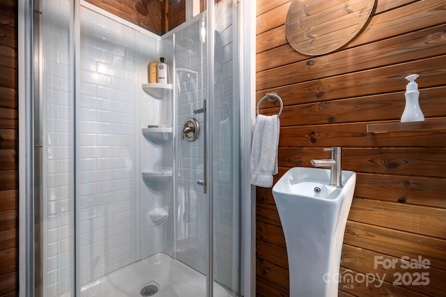 bathroom featuring wood walls and an enclosed shower