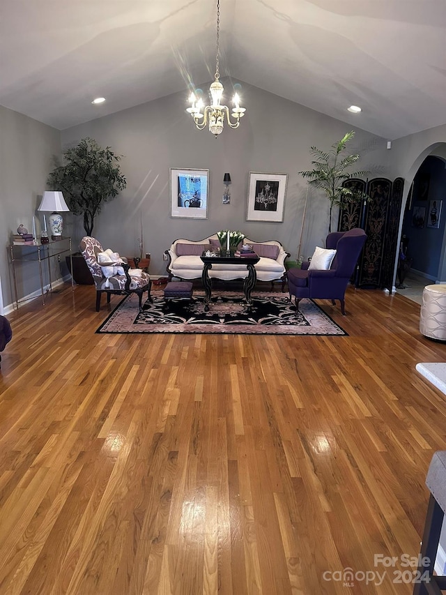 dining room featuring hardwood / wood-style flooring, lofted ceiling, and a notable chandelier