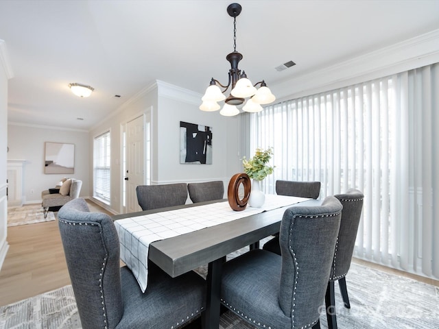 dining room featuring crown molding, a notable chandelier, and light hardwood / wood-style floors