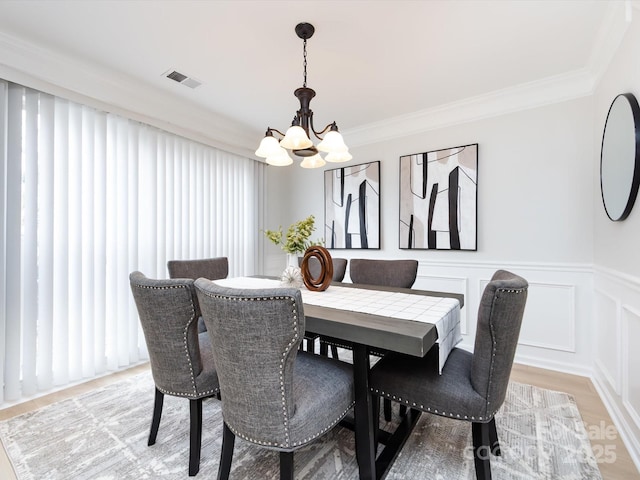 dining room featuring crown molding, a chandelier, and light wood-type flooring