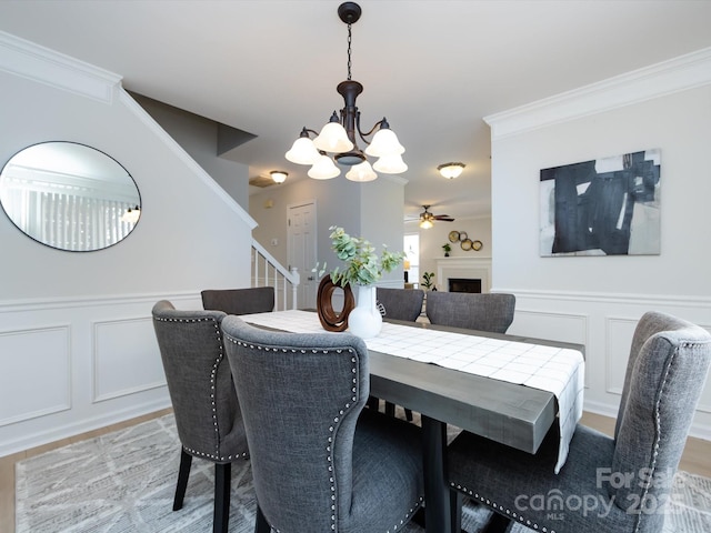 dining area featuring ceiling fan with notable chandelier and ornamental molding