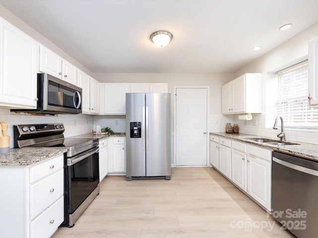 kitchen featuring stainless steel appliances, sink, and white cabinets