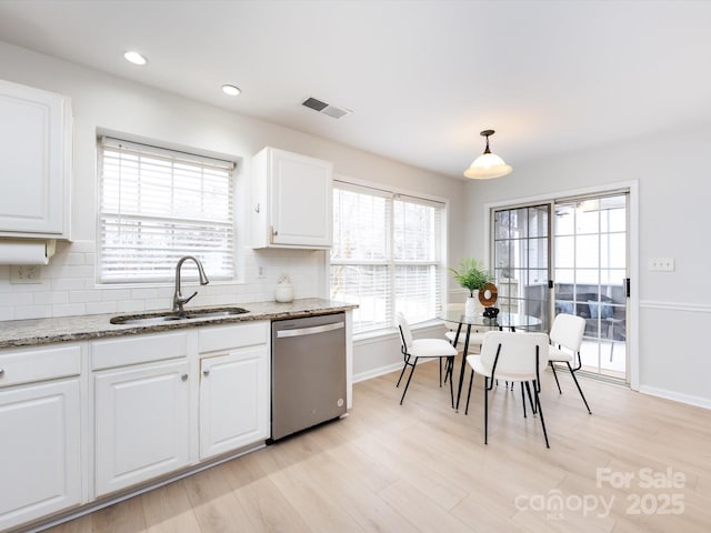 kitchen featuring pendant lighting, dishwasher, sink, and white cabinets