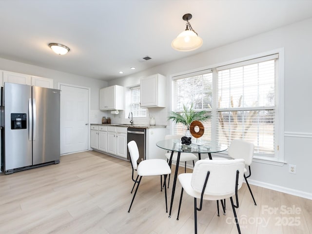 dining room featuring sink and light hardwood / wood-style floors