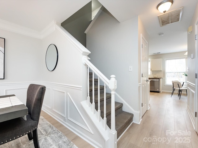 stairway featuring ornamental molding and hardwood / wood-style floors