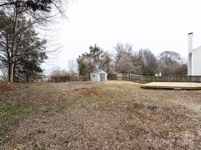 view of yard featuring a wooden deck and a shed