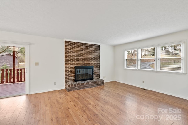 unfurnished living room with a fireplace and light hardwood / wood-style floors