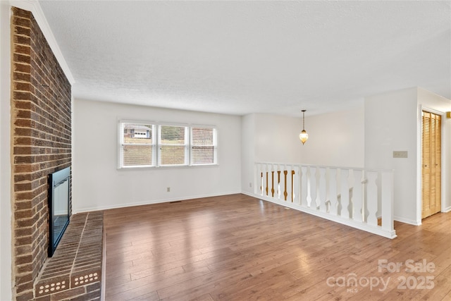 unfurnished living room featuring a textured ceiling, a fireplace, and hardwood / wood-style floors