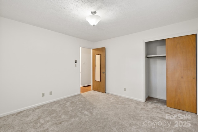 unfurnished bedroom with a textured ceiling, light carpet, and a closet