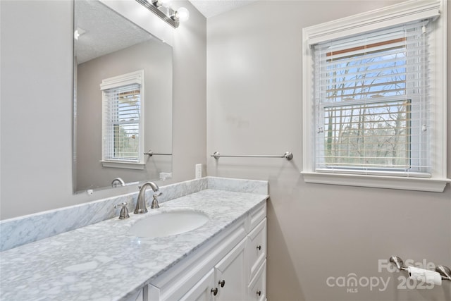 bathroom with a textured ceiling, vanity, and plenty of natural light