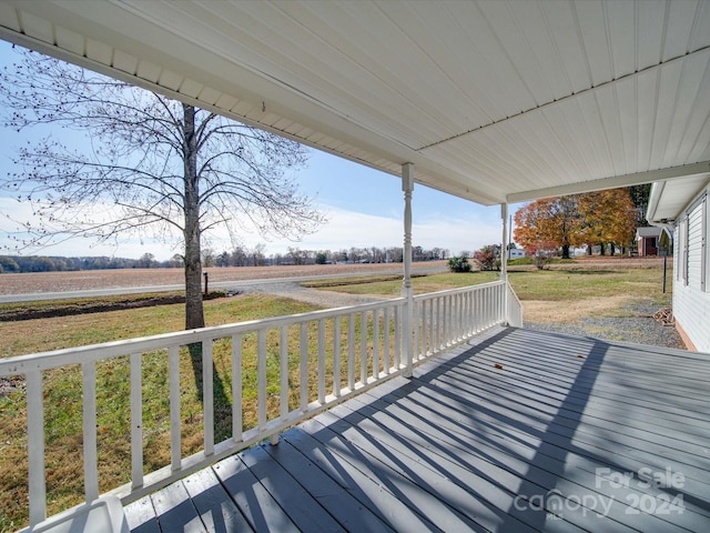 wooden terrace featuring covered porch and a rural view