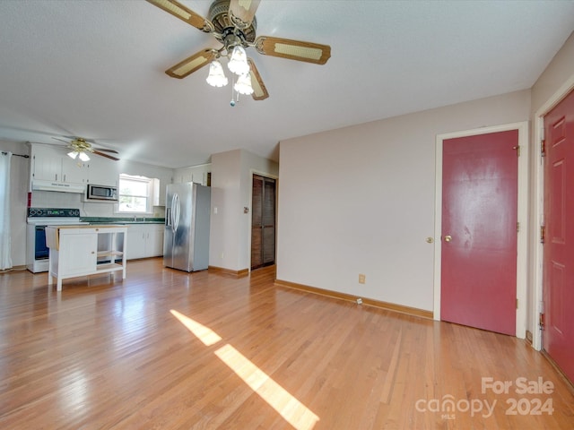 unfurnished living room with light hardwood / wood-style flooring and ceiling fan