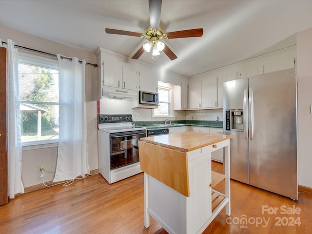 kitchen featuring white cabinets, light wood-type flooring, stainless steel appliances, and a breakfast bar area