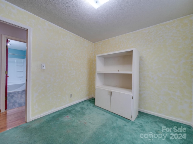 unfurnished bedroom with carpet floors and a textured ceiling